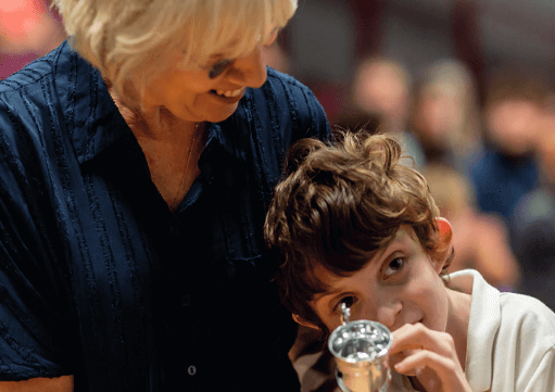 Teacher with a young student with a cup for winning an award