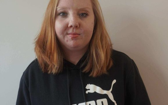 Jayleigh stood proudly in her black jumper smiling.