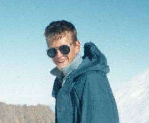 Photo of Paul Mclaren in his winter gear and sunglasses on a snowy mountain