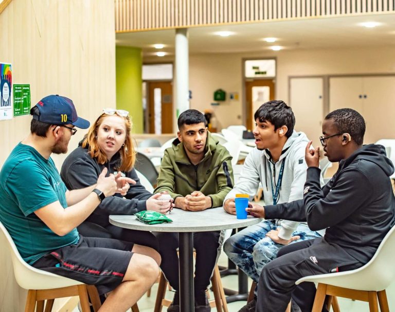 5 students around the table chatting