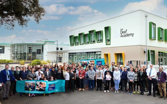 Students and staff outside the Deaf Academy building showing the Ofsted Good Provider banner for school and college sixth form