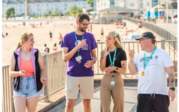 Deaf Academy students and teacher walking along Exmouth seafront
