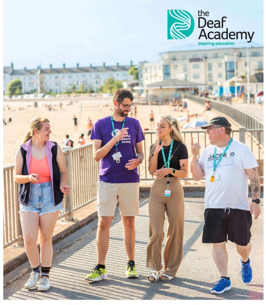 Deaf Academy students and teacher walking along Exmouth seafront